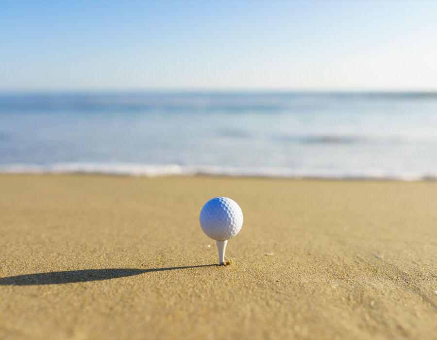 People playing golf near the sandy beach with ocean views in Manhattan Beach.