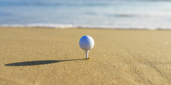 People playing golf near the sandy beach with ocean views in Manhattan Beach.