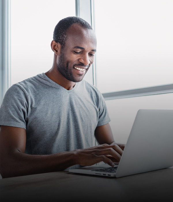 Man concentrating on his laptop in a bright, collaborative co-working space with modern decor.